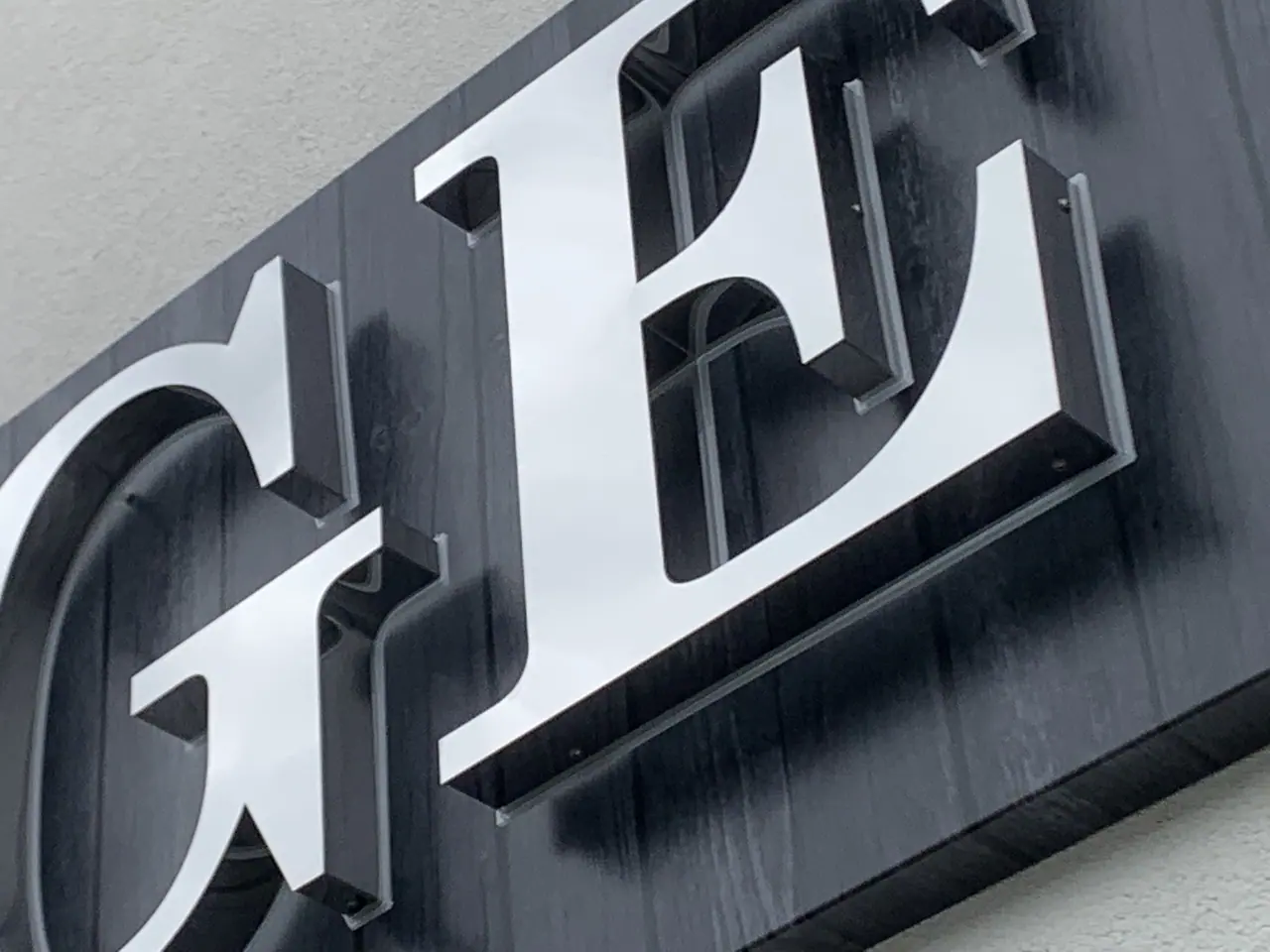 Large stainless steel 3D letters on a dark wall