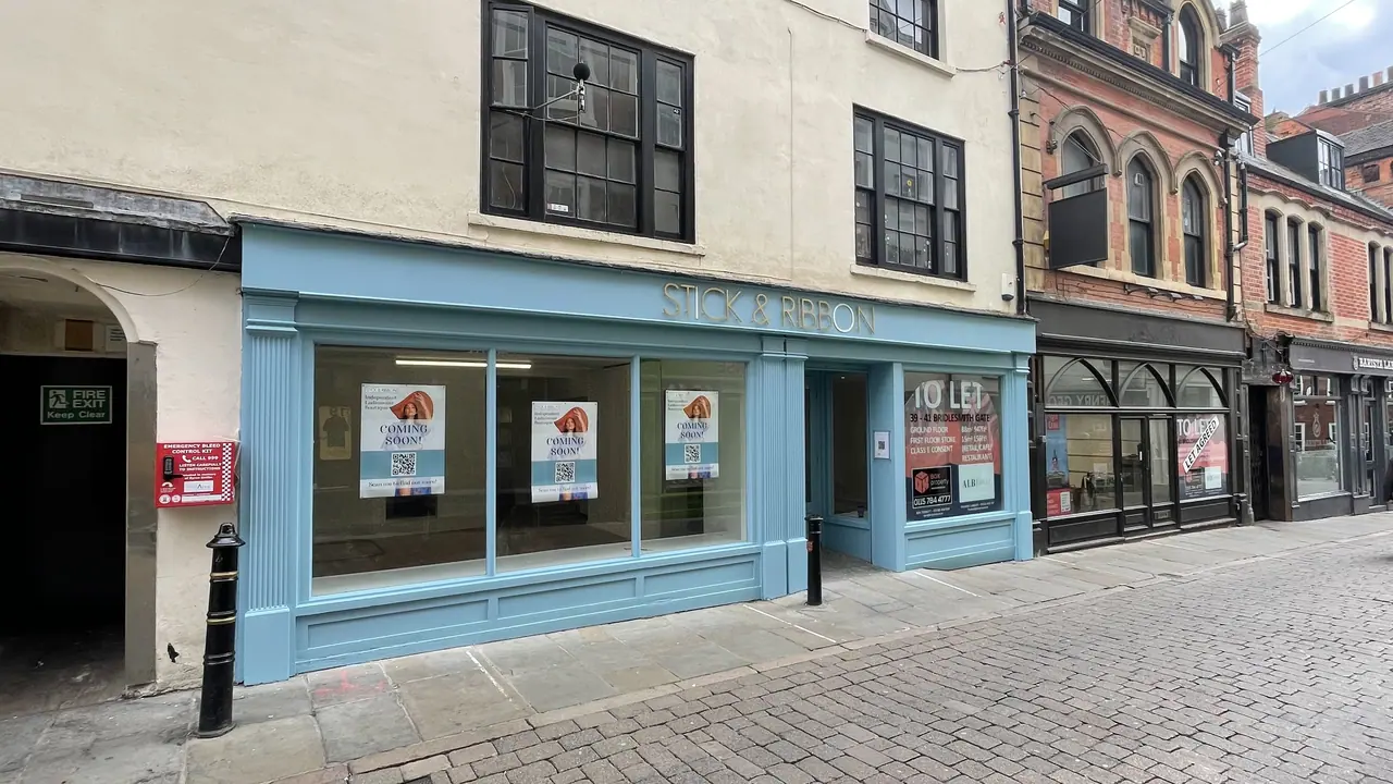 Light blue painted shop front with window graphics